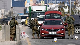 جنود إسرائيلون يفتشون سيارة فلسطينية عند معبر أريحا