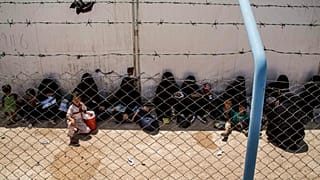 Women and children related to fighters of the Islamic State group wait to board buses and trucks to their homes on Monday, June 3, 2019.