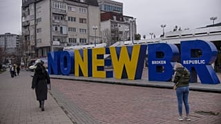 Kosovan Albanians walk past the newborn monument changed to "No New Broken Republic" in Pristina on February 27, 2023.