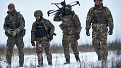 Ukrainian soldiers carrying a drone in combat