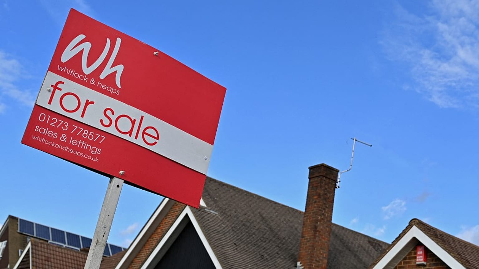 A for sale sign outside a house in England. 