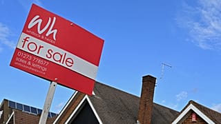 A for sale sign outside a house in England.