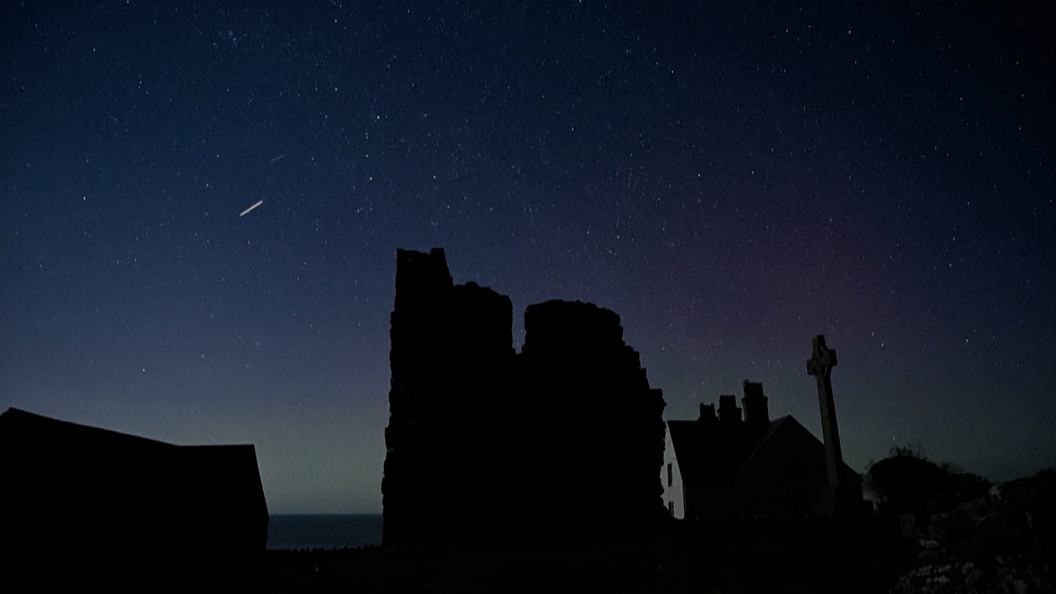 The Aurora Borealis visible in the night sky over Ynys Enlli, Wales