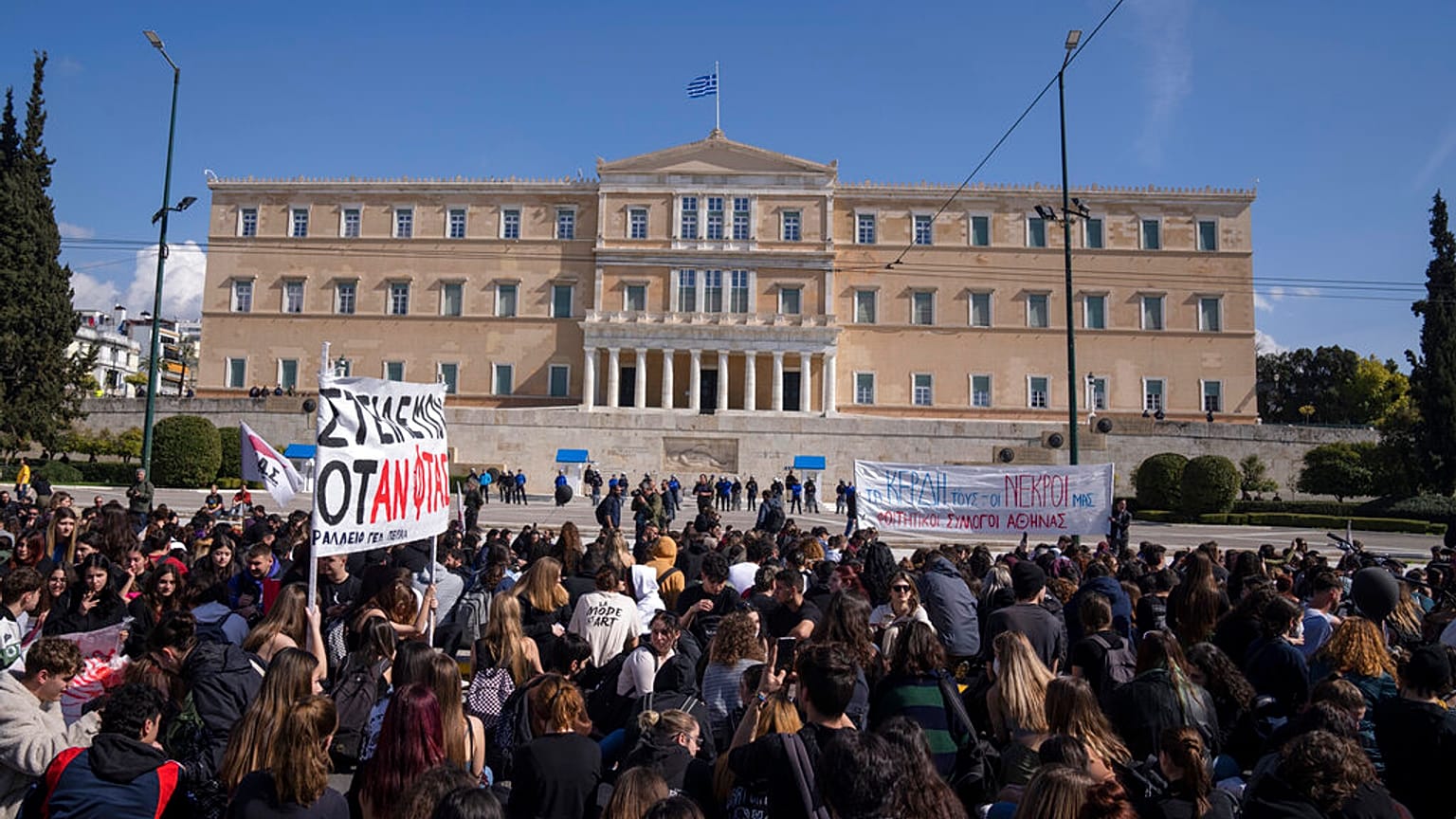 University students seat on the road in front of the greek Parliament as they pay respects to the victims of the train accident, in Athens, Friday, March 3, 2023