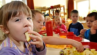 Emely, left, and other children have breakfast at a Kita, 7 October, in Grimma, Saxony.