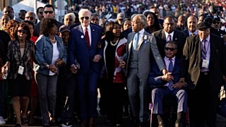 Biden Hand in Hand mit der Abgeordneten Terri Sewell und Reverend Al Sharpton auf der Edmund-Pettus-Brücke in Selma