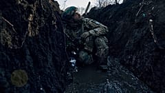 A Ukrainian soldier takes cover in a trench under Russian shelling on the frontline close to Bakhmut, Donetsk region, Ukraine, Sunday, March 5, 2023.