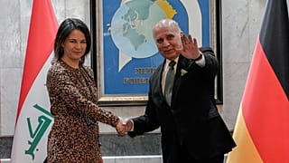 وزير الخارجية العراقي فؤاد حسين يصافح وزيرة الخارجية الألمانية أنالينا بيربوك أثناء زيارتها الرسمية للعراق