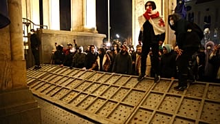 متظاهرون يتجمعون عند حاجز أمني منهار  في مبنى البرلمان الجورجي في تبليسي - جورجيا. 2023/03/07