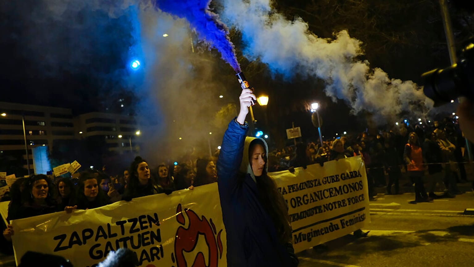 A woman holds a flare while taking part in a demonstration on International Women's Day, in northern Spain