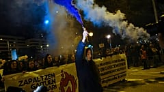 A woman holds a flare while taking part in a demonstration on International Women's Day, in northern Spain