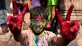 طفل هندي يحتفل بعيد الألوان