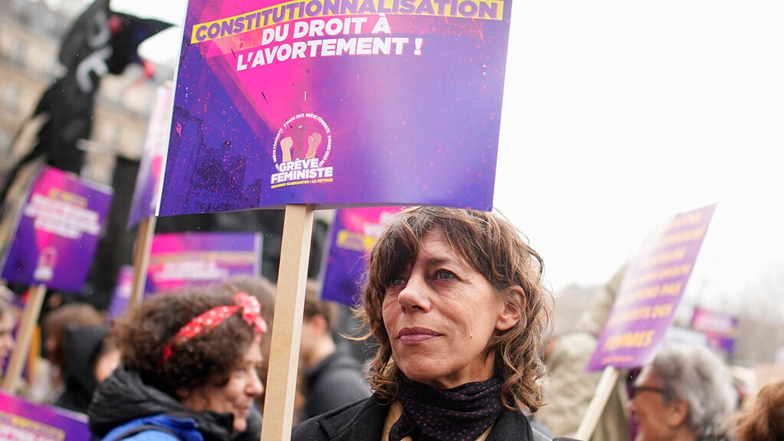 A woman demonstrates with a poster reading "Abortion in the Constitution" as part of the International Women's Day, Wednesday, March 8, 2023 in Paris.