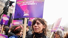 A woman demonstrates with a poster reading "Abortion in the Constitution" as part of the International Women's Day, Wednesday, March 8, 2023 in Paris.