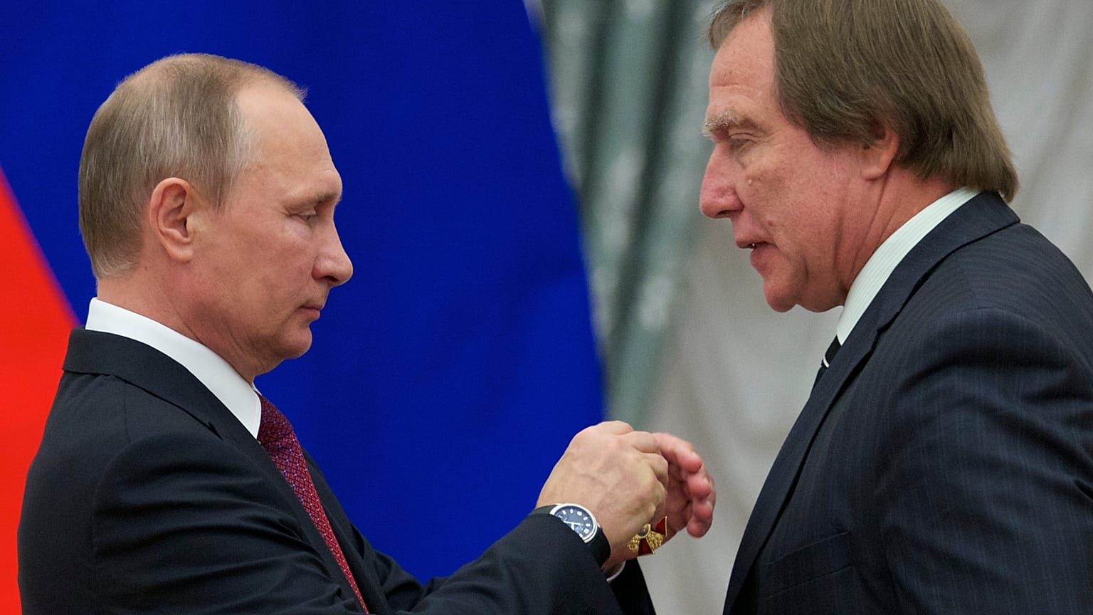 Russian President Vladimir Putin, left, presents a medal to Russian cellist Sergei Roldugin, during an awarding ceremony in Moscow's Kremlin, Russia, Sept. 22, 2016