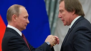 Russian President Vladimir Putin, left, presents a medal to Russian cellist Sergei Roldugin, during an awarding ceremony in Moscow's Kremlin, Russia, Sept. 22, 2016