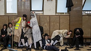 Ultra-Orthodox Jewish men celebrate after getting drunk during the Jewish holiday of Purim in Mea Shearim ultra-Orthodox neighborhood in Jerusalem, Wednesday, March 8, 2023.