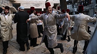 Des juifs ultra-orthodoxes costumés célèbrent Pourim dans le quartier de Mea Shearim à Jérusalem, le 8 mars 2023.