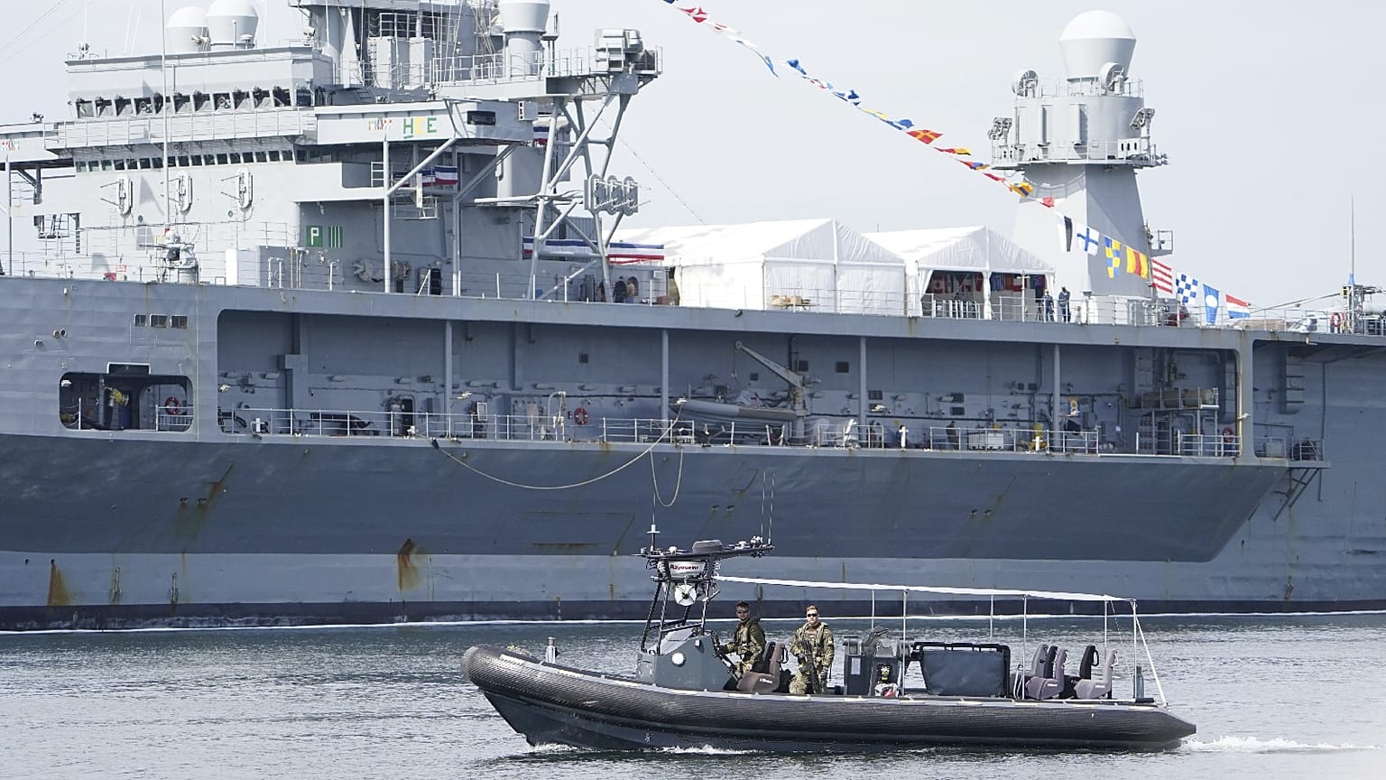 Armed Navy soldiers patrol in front of US lead ship "USS Mount Whitney" after the end of the Baltic Operations (BALTOPS) maneuver, Kiel, Germany, June 17, 2022.