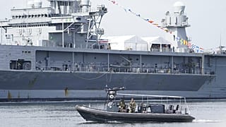 Armed Navy soldiers patrol in front of US lead ship "USS Mount Whitney" after the end of the Baltic Operations (BALTOPS) maneuver, Kiel, Germany, June 17, 2022.