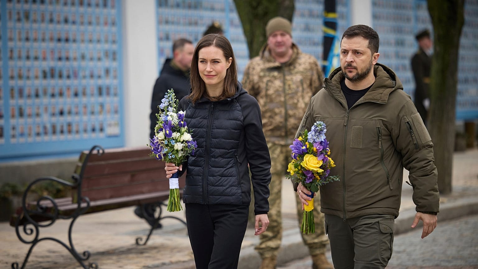 Finland's Prime Minister Sanna Marin and Ukrainian President Volodymyr Zelenskyy hold flowers at the Memorial Wall of Fallen Defenders of Ukraine in Russian-Ukrainian War, in 