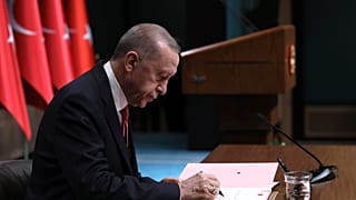 إردوغان موقعاً القرار الذي ينص على إجراء الانتخابات الرئاسية في 10 آذار-مارس 