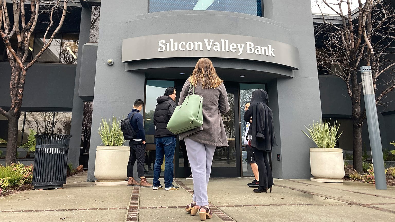 People stand outside of an entrance to Silicon Valley Bank in Santa Clara, California, 10 March 2023