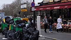 Eine Straße in Paris: Berge von Müllsäcken und überfüllte Mülleimer