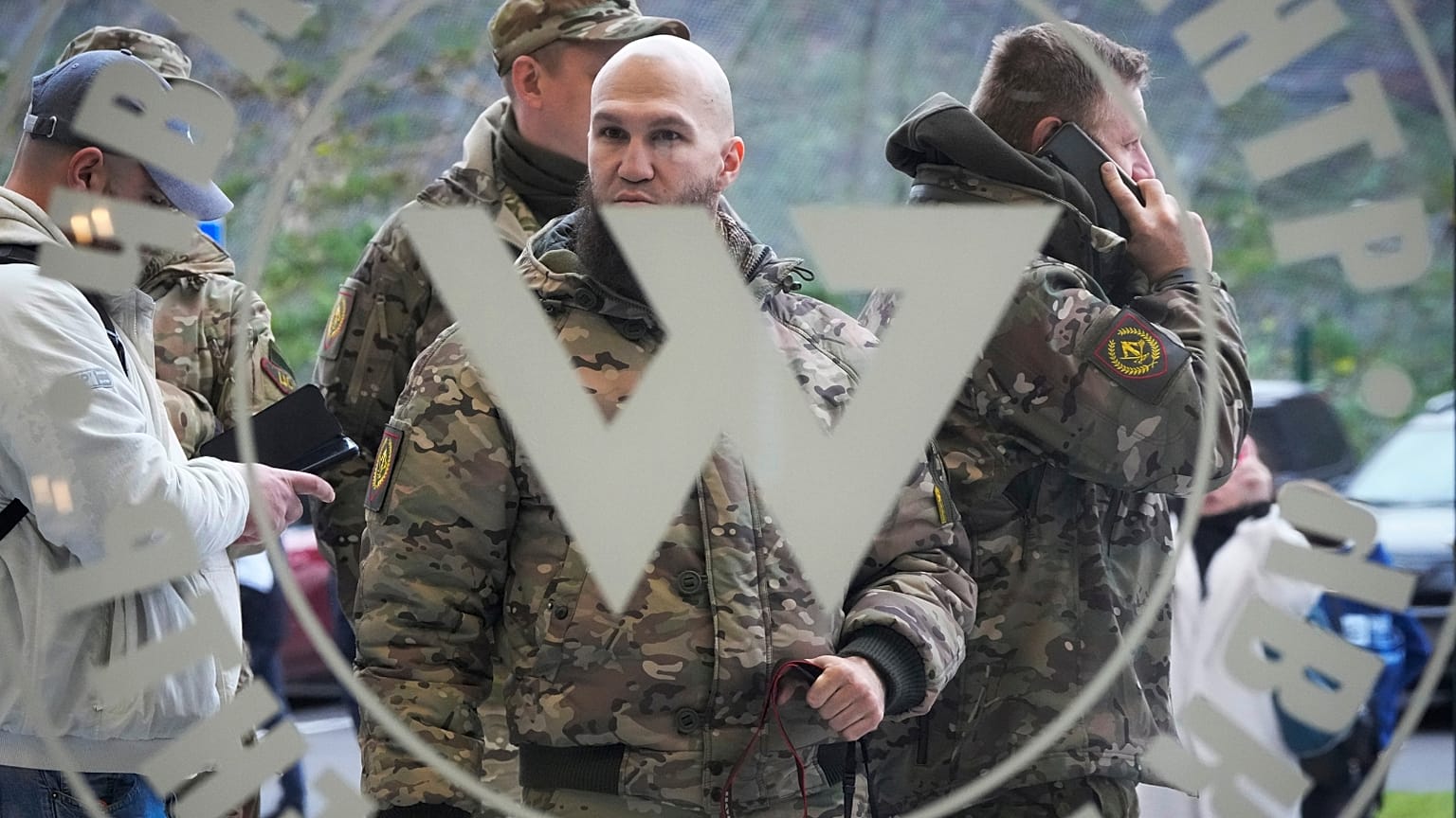 FILE: Visitors wearing military camouflage stand at the entrance of the 'PMC Wagner Centre', St Petersburg