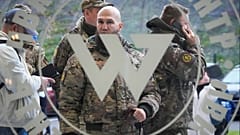 FILE: Visitors wearing military camouflage stand at the entrance of the 'PMC Wagner Centre', St Petersburg