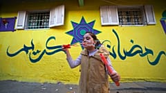 طفلة فلسطينية أمام أحد الجدران الملونة بالبلدة القديمة في غزة 