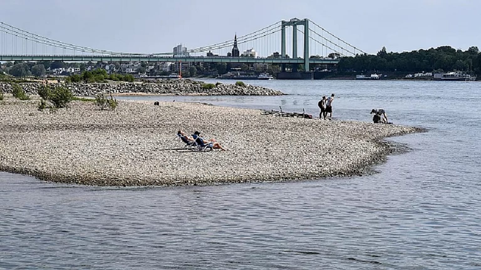People enjoy the sunny weather on dry river banks of Germany's most important river Rhine in Cologne, Germany, after a long time of drought, 27 April 2020. 