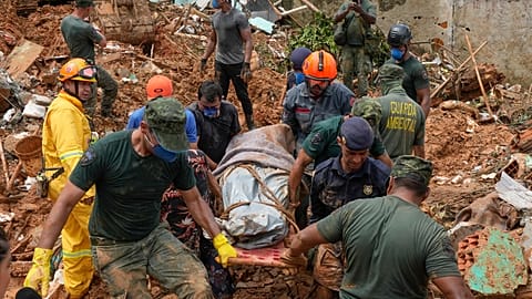 Rescue workers and volunteers carry the body of a landslide victim near Barra do Sahy beach after heavy rains in the coastal city of Sao Sebastiao, Brazil