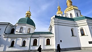 Monges caminham junto ao mosteiro Pechersk Lavra
