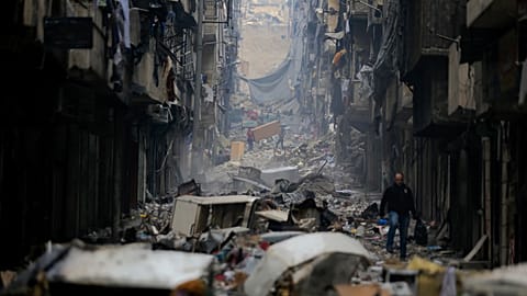 Residents walk through the destruction caused by war in the once rebel-held Salaheddine neighborhood in eastern Aleppo in 2017.