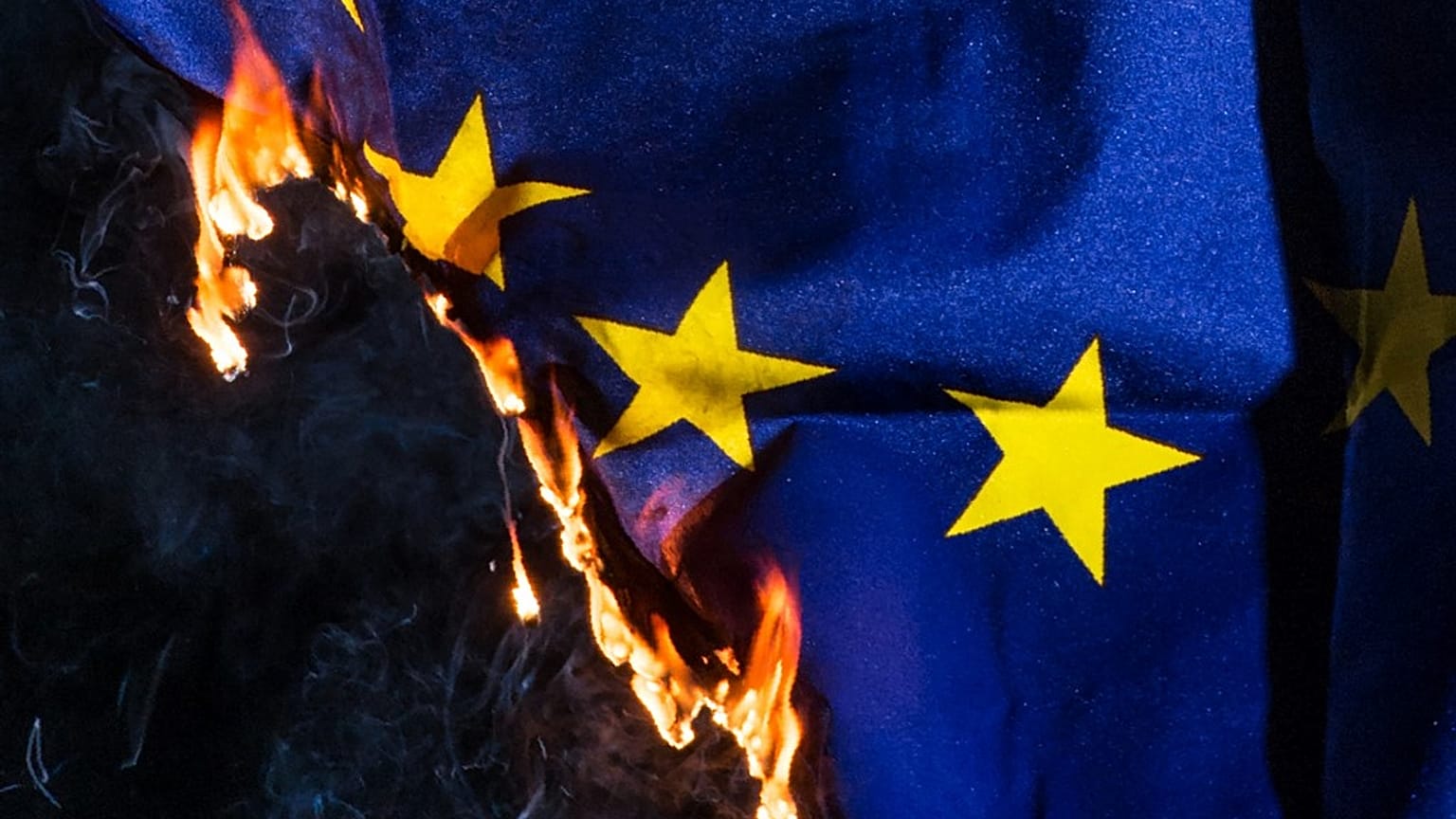 An EU flag burns. 