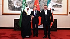 علي شمخاني (يمين) يصافح مساعد بن محمد العيبان عقب الاتفاق في بكين