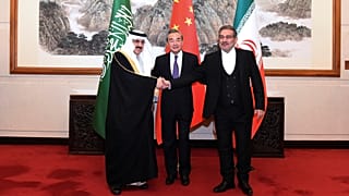 علي شمخاني (يمين) يصافح مساعد بن محمد العيبان عقب الاتفاق في بكين