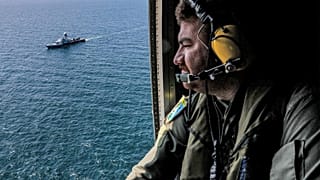 Иранский военный наблюдает за учениями в Аравийском море