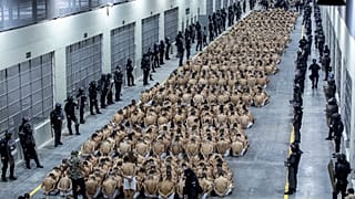 Inmates identified by authorities as gang members are seated on the prison floor of the Terrorism Confinement Center in Tecoluca, El Salvador, Wednesday, March 15, 2023.
