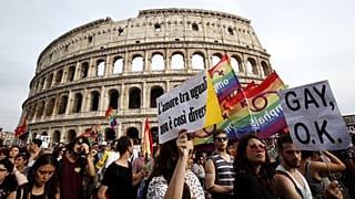 People march past the Colosseum during the Gay Pride parade in Rome, June 11, 2016.