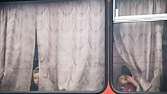 Ukrainische Kinder werden mit einem Bus in ein Flüchtlingslager der russischen Behörden gebracht.