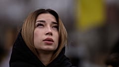 Украинка у могилы своего погибшего мужа на кладбище в Буче