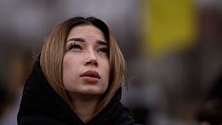 Украинка у могилы своего погибшего мужа на кладбище в Буче