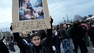"König des Abfalls" steht auf dem Plakat dieser Demonstrantin in Paris