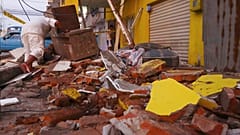 A resident recovers belongings amid the debris of a collapsed home after an earthquake shook Machala, Ecuador, March 18, 2023. 