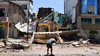 A man takes a photo of a building that collapsed after an earthquake shook Machala, Ecuador, Saturday, March 18, 2023. 