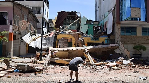 A man takes a photo of a building that collapsed after an earthquake shook Machala, Ecuador, Saturday, March 18, 2023. 