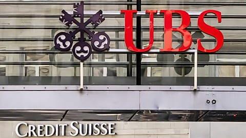 Logos of the Swiss banks Credit Suisse and UBS are seen on two buildings in Zurich, Switzerland, Saturday, March 18, 2023. 