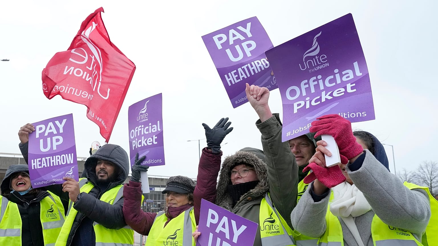 Members of the Unite union stand at a picket line near Heathrow Airport in London.